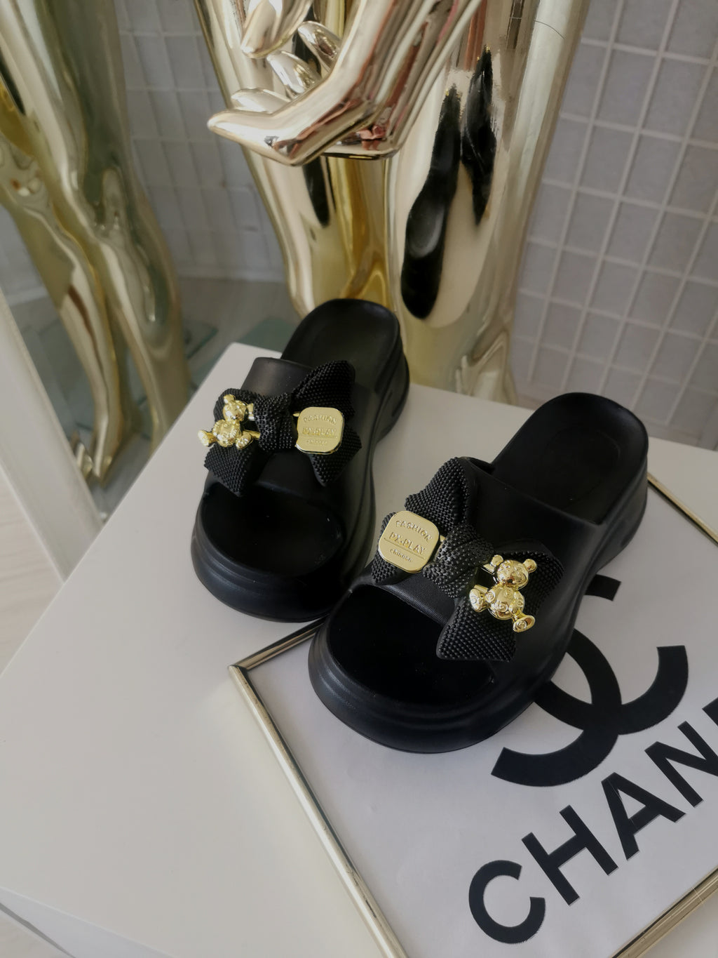 Juodos tapkės su kaspinu bei auksinės spalvos detalėmis