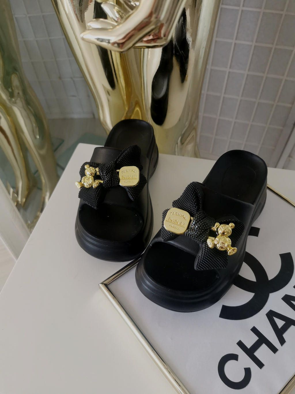 Juodos tapkės su kaspinu bei auksinės spalvos detalėmis